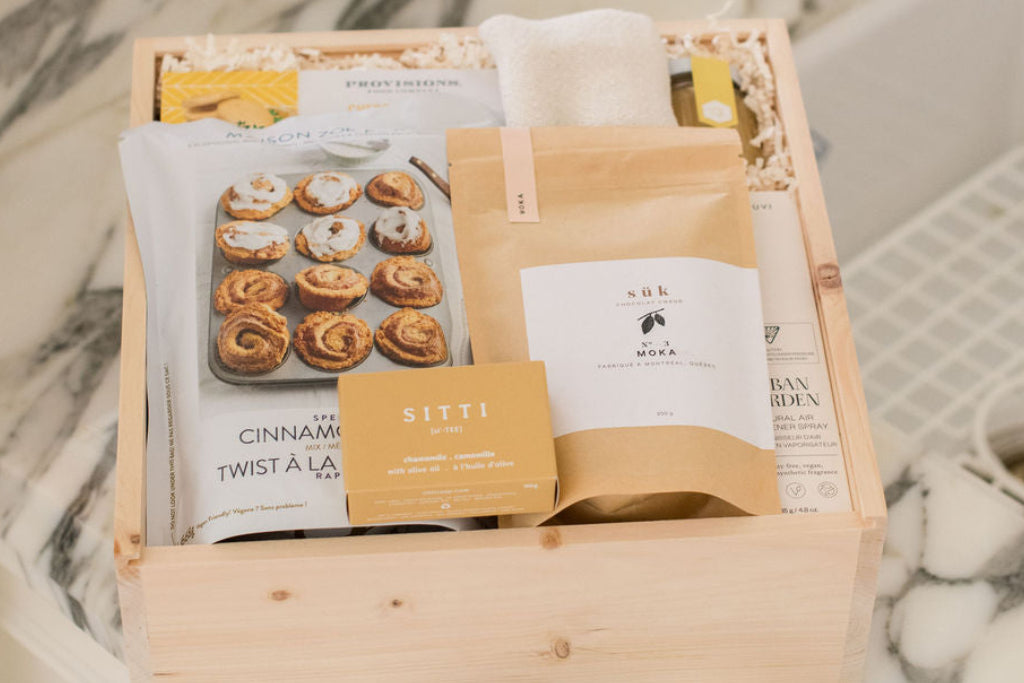 Gift basket with pastries and a candle on a marble countertop